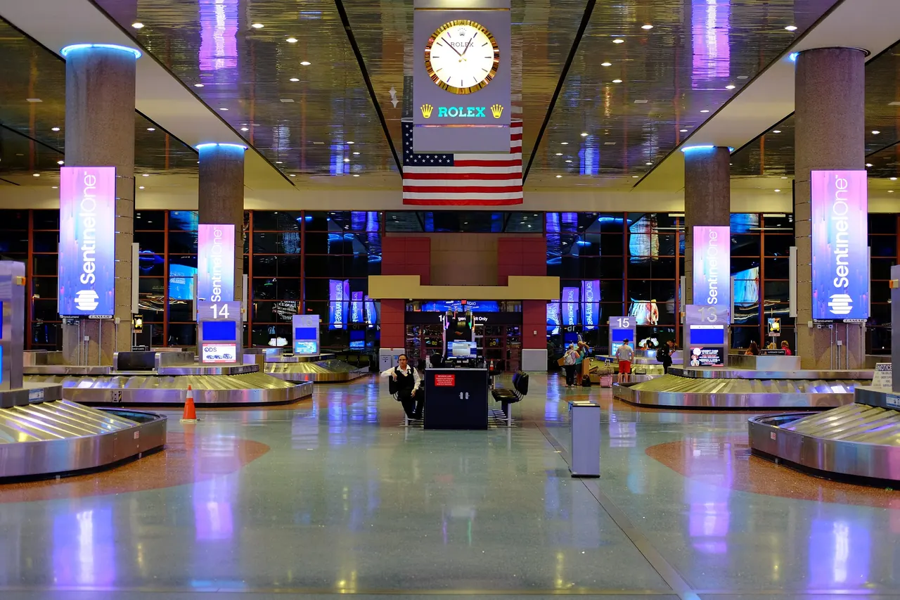 Baggage claim carousels under a large wall clock in Terminal 1 at Las Vegas airport