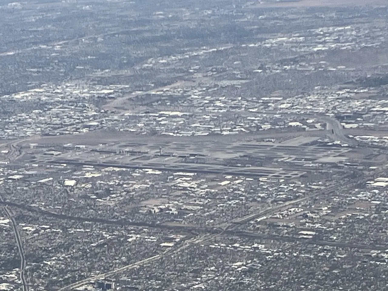Aerial view of Phoenix Sky Harbor International Airport showing its runways beside the surrounding city grid