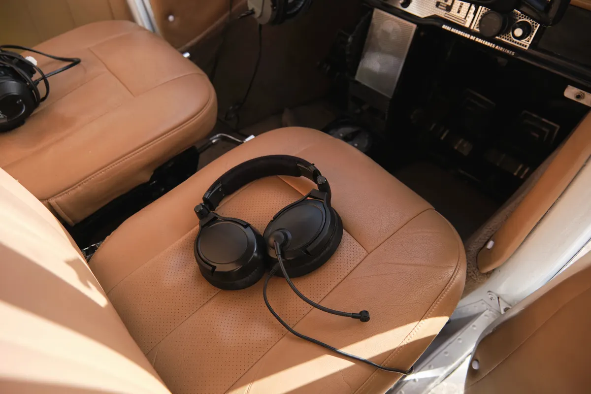 An aviation headset resting on a pilot seat in a small airplane cockpit