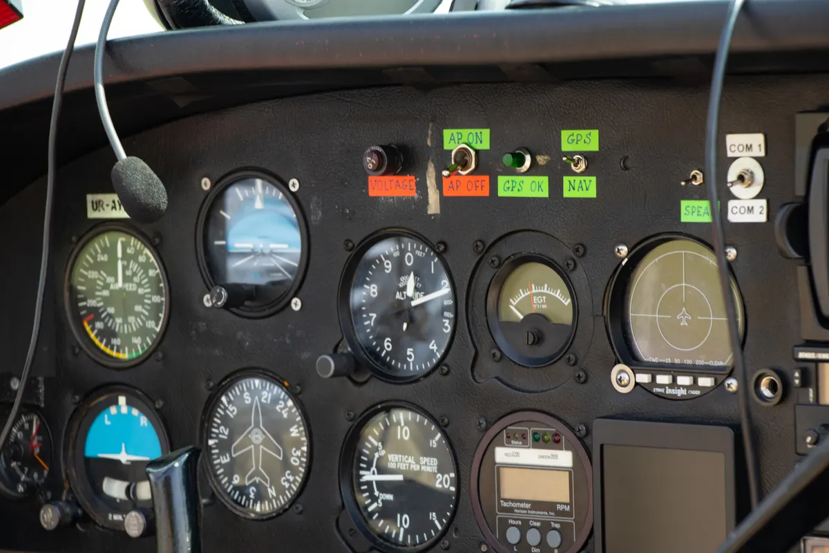 The flight instrument panel of a small airplane with round analog gauges