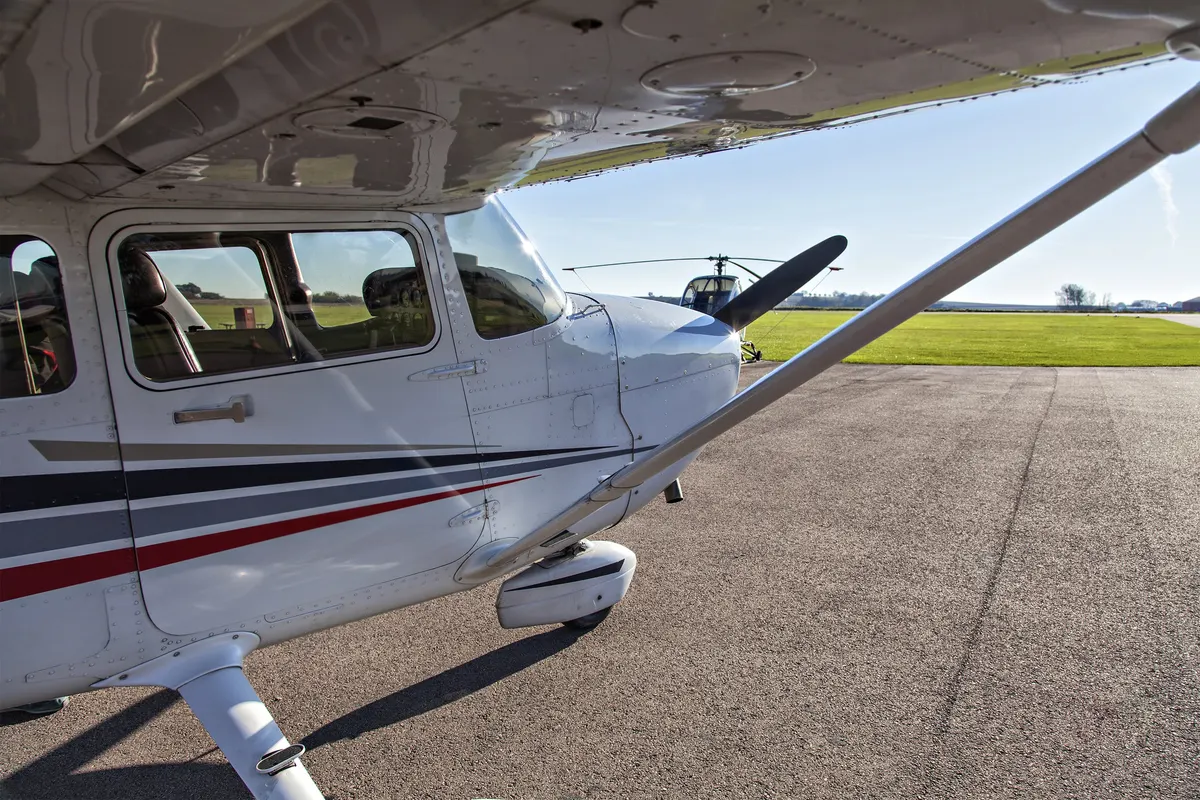 A single-engine light airplane parked on an airport ramp on a sunny day