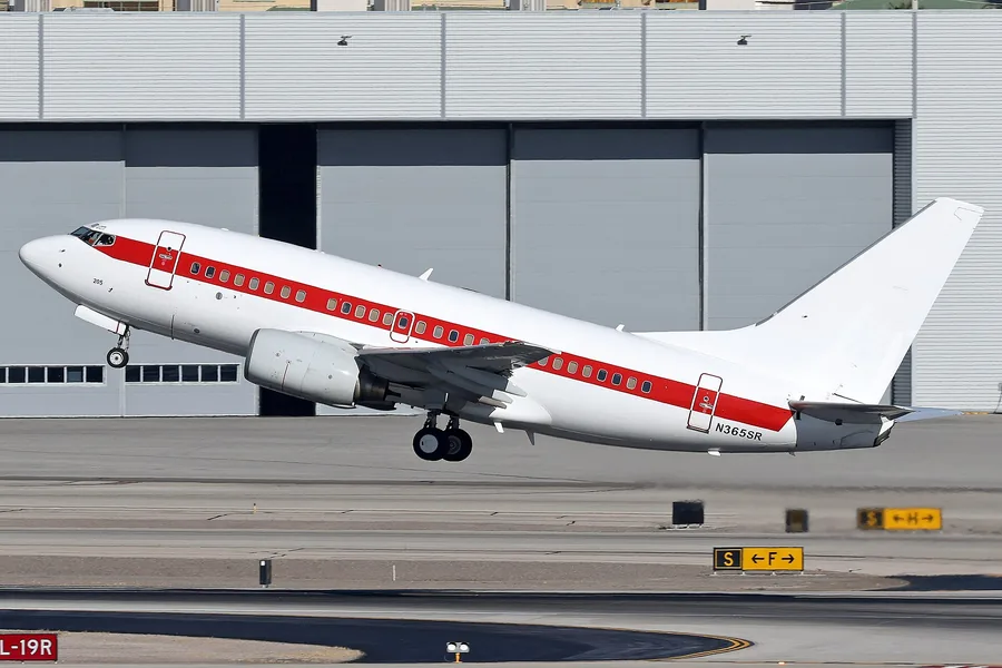 White Boeing 737-600 with a red stripe, registration N365SR, climbing out of Las Vegas