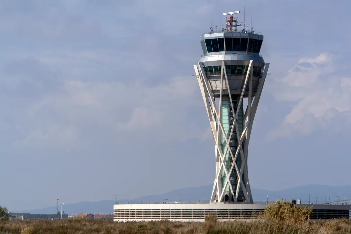 An airport air traffic control tower against a blue sky
