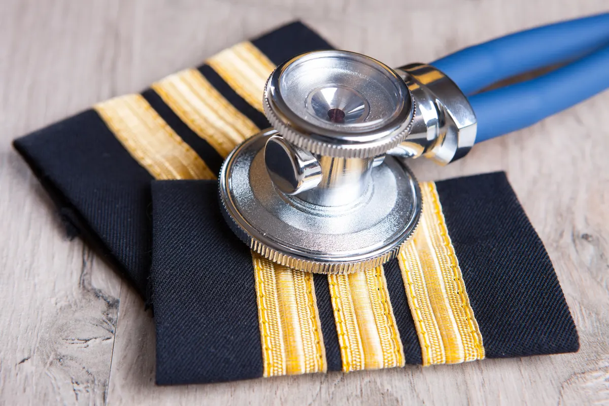 A stethoscope resting on pilot uniform epaulettes with gold stripes